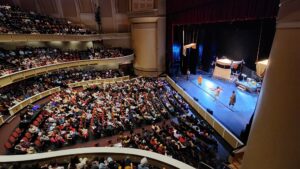 Photo of the audience and stage at Merrill Auditorium