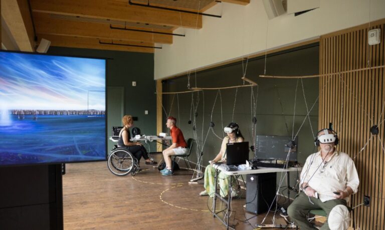 People participating in 'territory' seated in chairs wearing VR headsets.